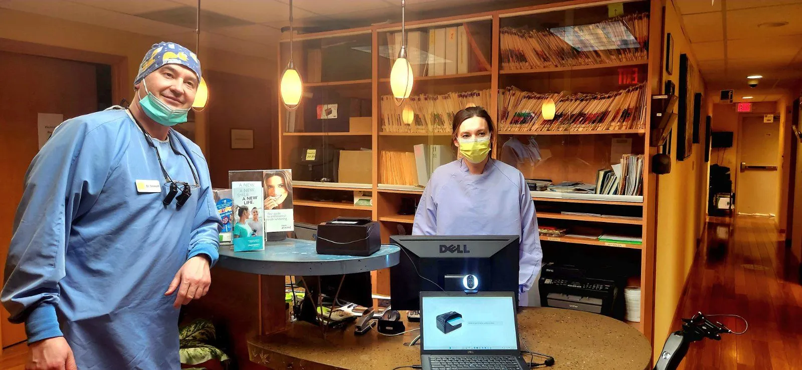 Adroit Dental team standing proudly in front of the kiosk system