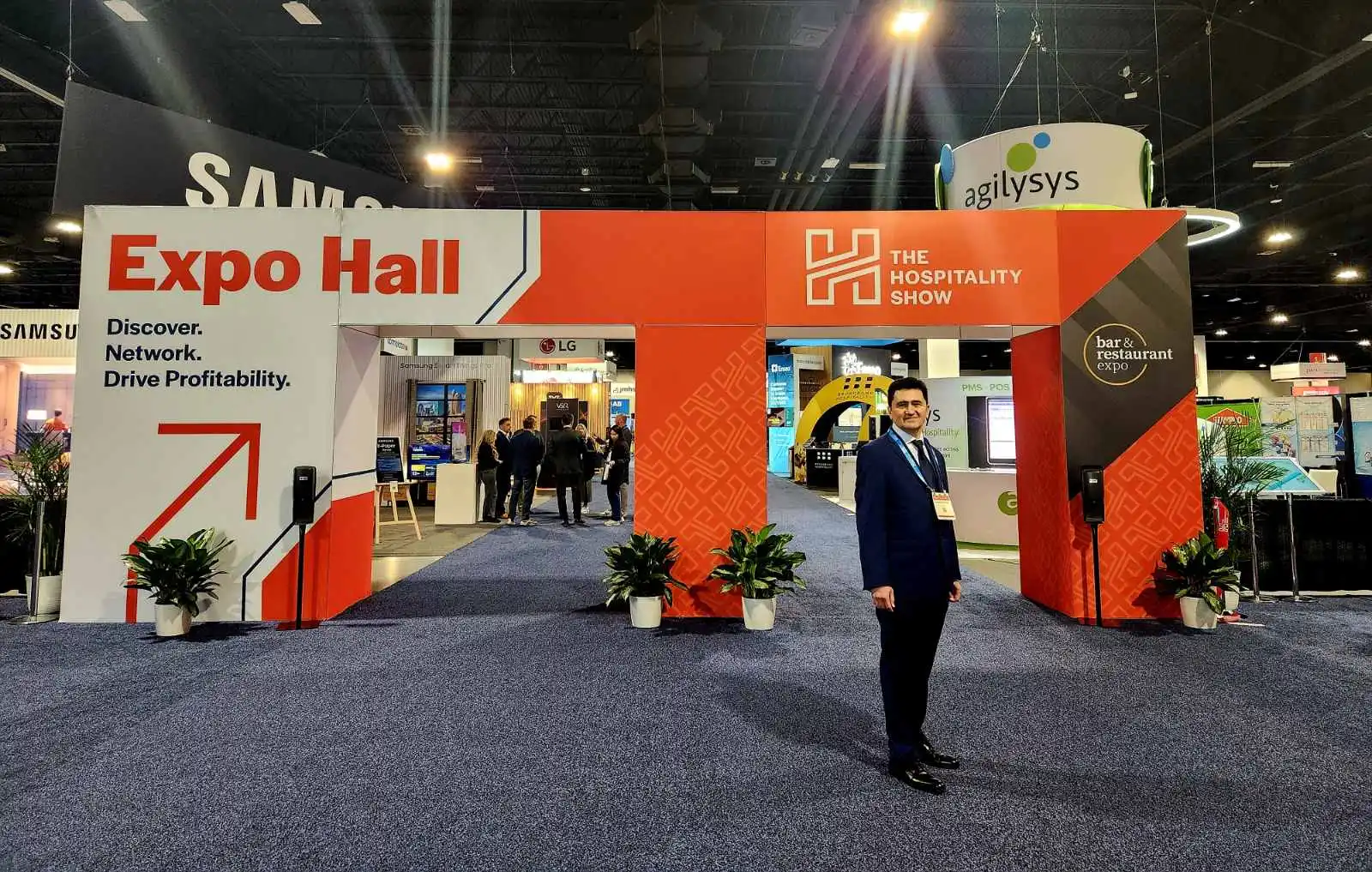 V5iD CEO at Expo Hall Entrance: Innovating Hospitality Identity Verification at The Hospitality Show 2025 in Denver, CO V5iD CEO standing confidently at the Expo Hall entrance of The Hospitality Show 2025, highlighting AI-driven identity verification opportunities.