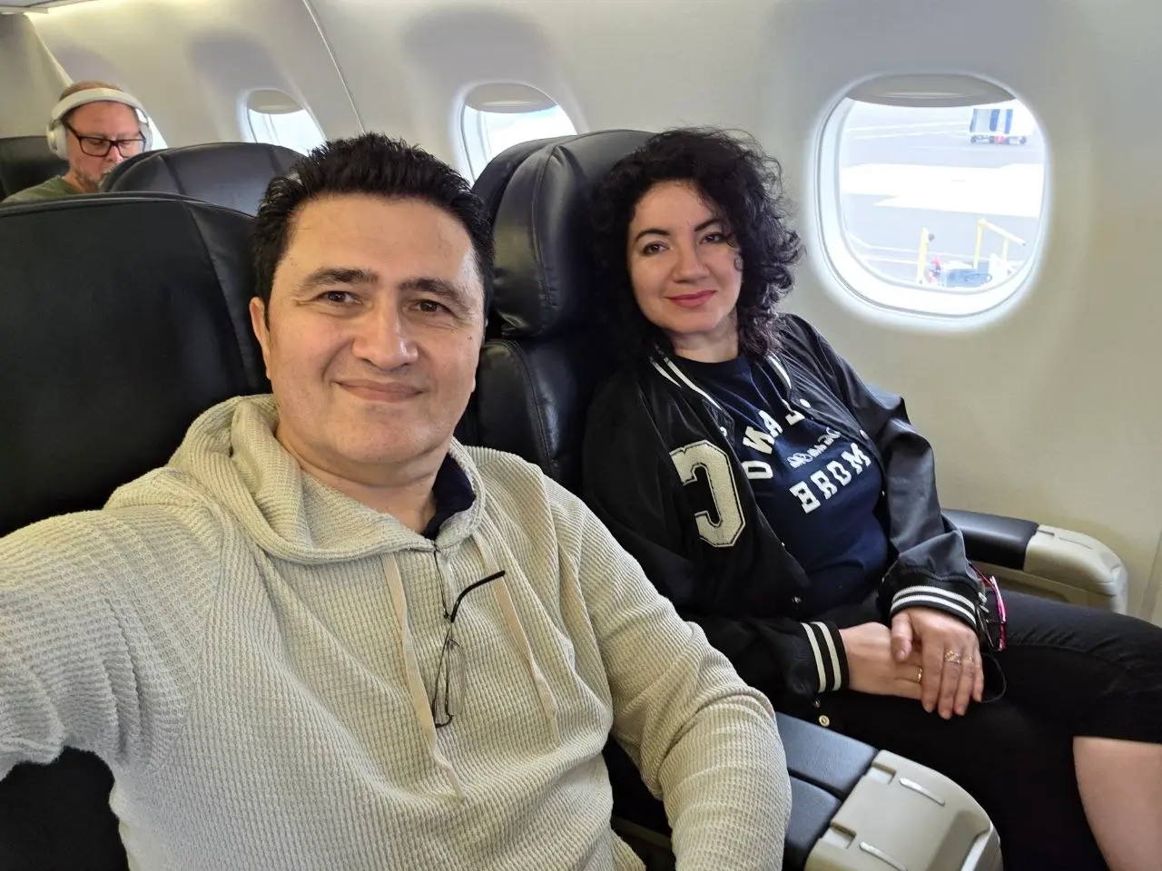 V5iD® CTO and CEO seated in an airplane window seat, smiling in a selfie before takeoff from Portland, Oregon, en route to the SymWest conference in Salt Lake City.