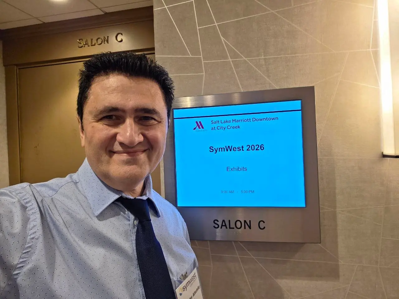 V5iD CTO taking a selfie in front of the Salon C digital display at the Salt Lake Marriott Downtown