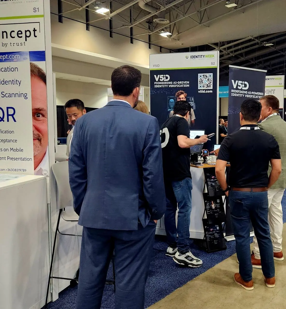 Group of industry professionals gathered around the V5iD booth examining AI-driven identity verification technology at Identity Week America 2026