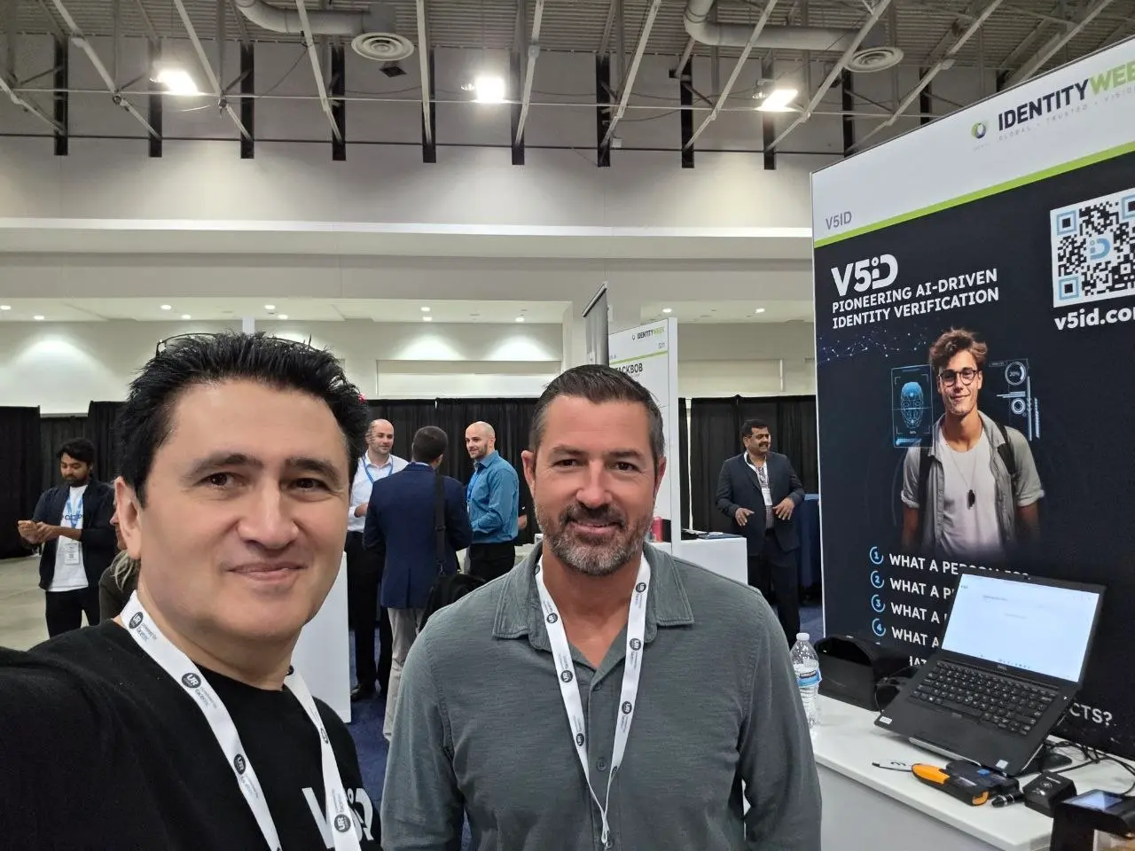 Selfie of V5iD team member with a conference attendee standing beside the V5iD AI-powered identity verification display at Identity Week America 2026