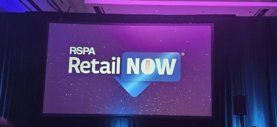 RSPA RetailNOW 2026 stage screen – V5iD at the show Large projection screen displaying the official RSPA RetailNOW 2026 logo with starry purple background at the Caesars Forum event in Las Vegas, where V5iD participated.