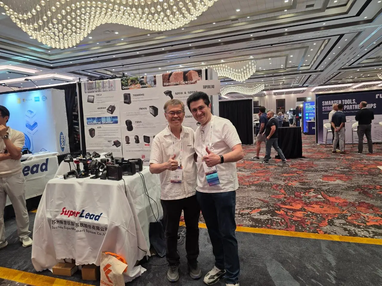 V5iD CTO at SuperLead device manufacturer booth, RSPA RetailNOW 2026 V5iD CTO posing with a SuperLead representative at the SuperLead scanners and device manufacturer booth during RSPA RetailNOW 2026 at Caesars Forum, Las Vegas, both giving a thumbs-up.